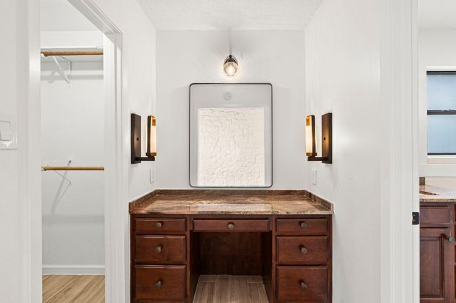 Bathroom with vanity, a walk in closet, and wood finished floors | Image 19