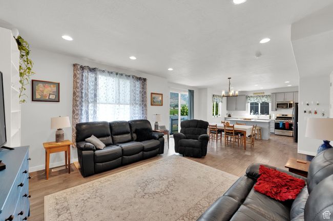 Living room featuring a chandelier, light wood finished floors, and recessed lighting | Image 10