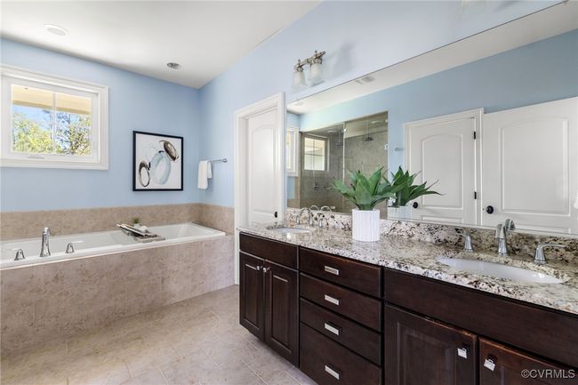 Tile floor, oversized soaking tub, raised double vanity with grantie counters, water closet, tile surround steam shower with tile pan | Image 25