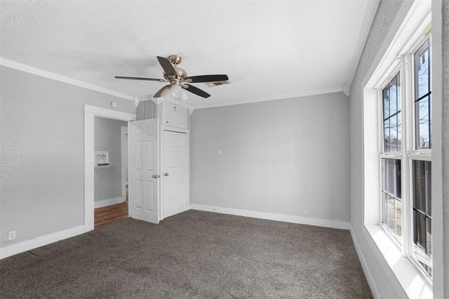 Unfurnished bedroom with ornamental molding, carpet floors, a textured ceiling, and a ceiling fan | Image 11