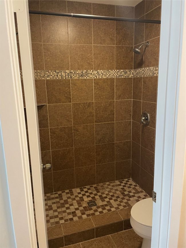 Bathroom with tile patterned floors, toilet, and a tile shower | Image 20