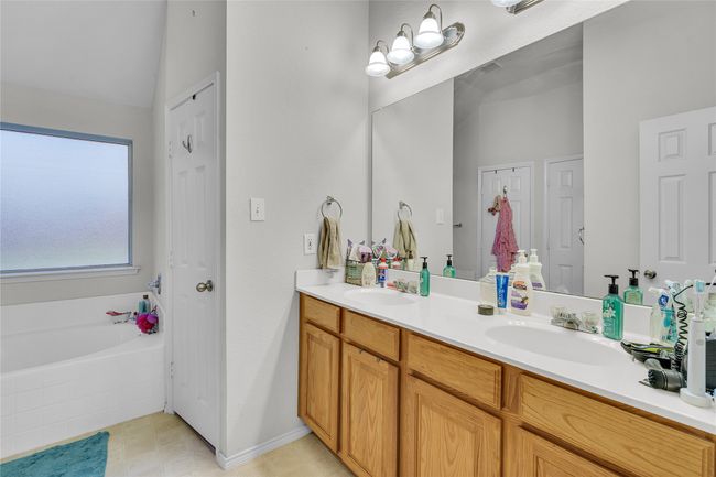 Full bathroom featuring double vanity, a garden tub, tile patterned flooring, and lofted ceiling | Image 20