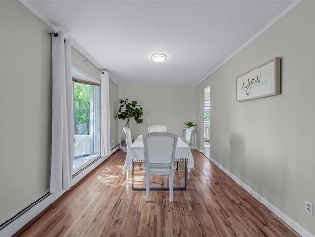 Dining space with wood finished floors and crown molding | Image 6