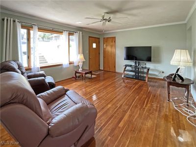 Living room with crown molding, ceiling fan, and hardwood / wood-style flooring | Image 2