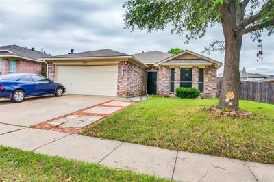 Ranch-style home with a front lawn and a garage | Image 1