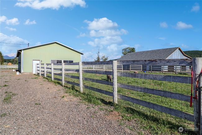 The shop building has an enclosed work shop area and open bays for machine or vehicle storage. There is lots of parking for the farm visitors | Image 37