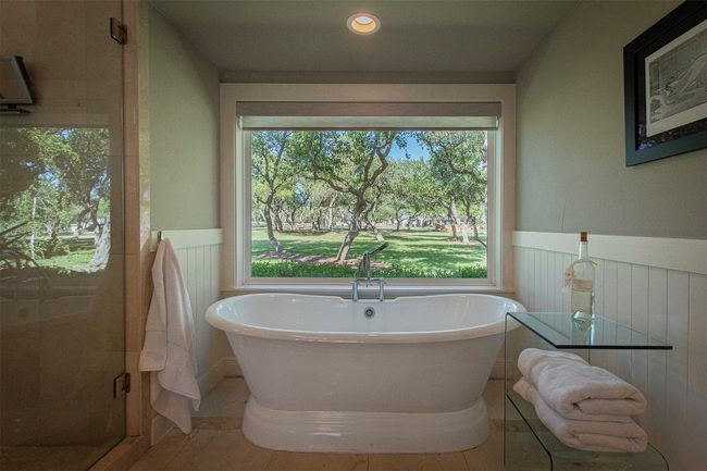 Bathroom featuring a wainscoted wall, tile patterned flooring, a soaking tub, and a stall shower | Image 21