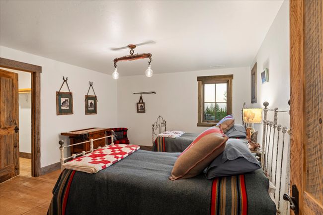 o bedrooms with huge closets and antique wrought iron beds in the basement along with spacious laundry closet and full bath with walk-in shower complete this peaceful charming home in the woods | Image 35