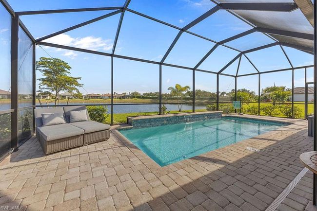 Outdoor pool with a lanai, a patio area, and a water view | Image 39