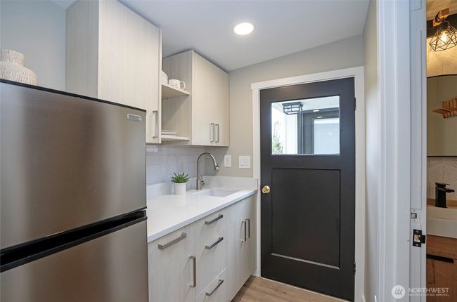 Attractive cabinets with a Quartz counter and new finishes make this an inviting hang out room. | Image 26