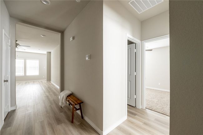 Hall with visible vents, light wood-type flooring, and baseboards | Image 9