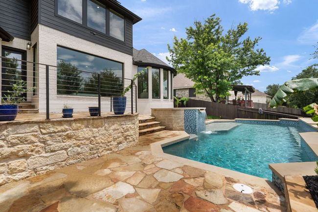 A cascading waterfall feature adds a soothing ambiance and visual appeal to this private outdoor retreat. | Image 32