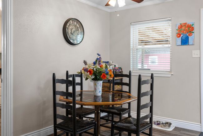 Dining space with crown molding, ceiling fan, and wood finished floors | Image 9