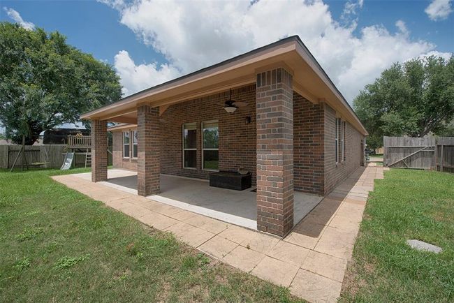 A view of the back patio from the yard. Fantastic paved stone surrounding the deck and even pathway to the gate to the front yard. | Image 31