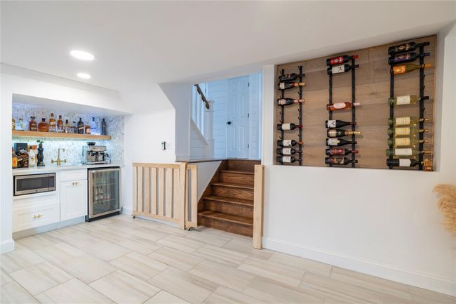 Bar with stairway, indoor bar, beverage cooler, stainless steel microwave, and recessed lighting | Image 14