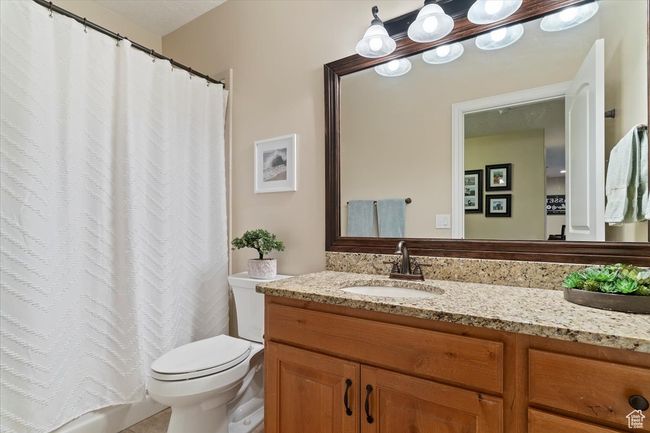 Bathroom featuring vanity, curtained shower, and toilet | Image 43