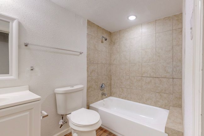 Full bathroom with vanity, tiled shower / bath, hardwood / wood-style floors, and toilet | Image 24