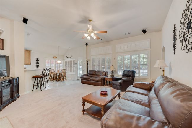Living room featuring ceiling fan, plenty of natural light, carpet floors, and baseboards | Image 9