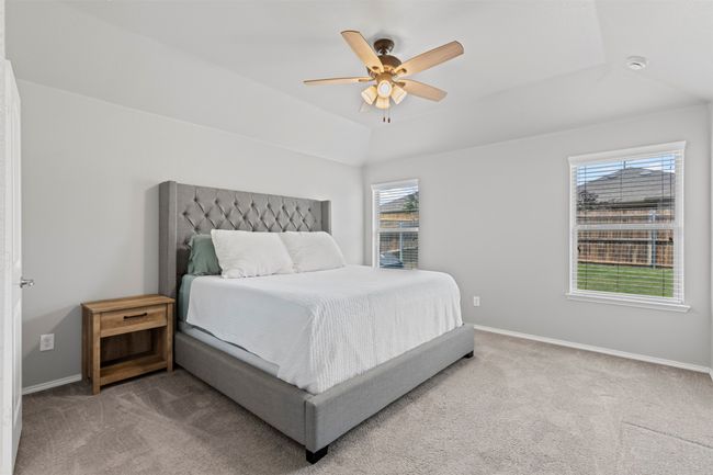 Carpeted bedroom featuring multiple windows, a ceiling fan, and vaulted ceiling | Image 14