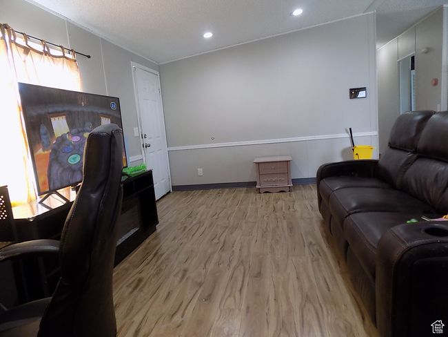 Living room featuring light hardwood / wood-style flooring and a textured ceiling | Image 4