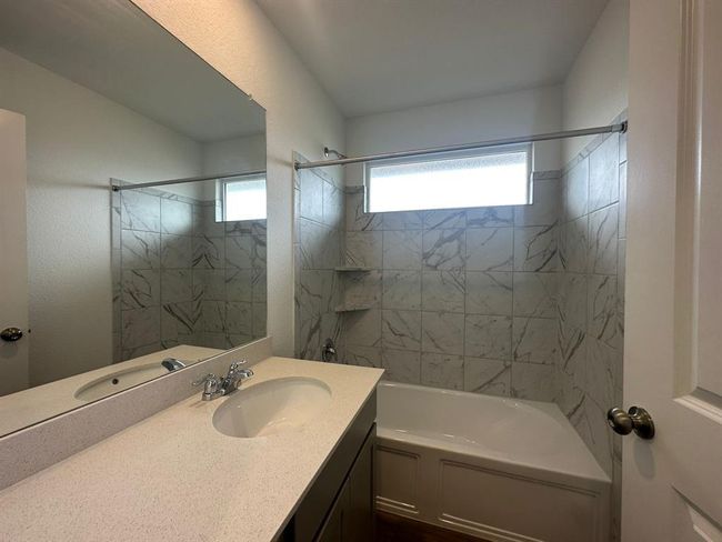 Full bathroom featuring plenty of natural light, vanity, and tub / shower combination | Image 11