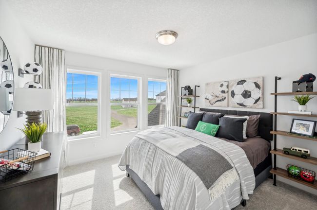 (Photo of a decorated model, actual homes finishes will vary) One of three generously sized upper level secondary bedrooms with spacious closets. | Image 17