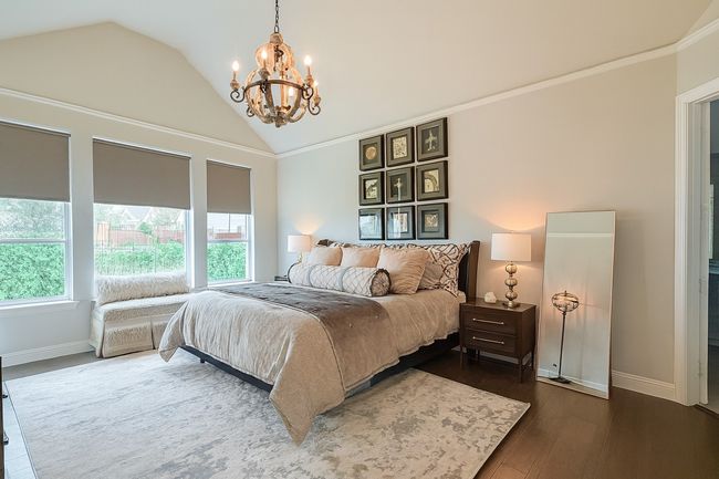 Bedroom featuring a chandelier, wood finished floors, ornamental molding, and high vaulted ceiling | Image 15