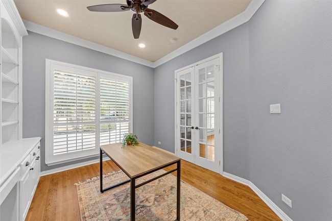 Home office with french doors, ornamental molding, light wood finished floors, ceiling fan, and baseboards | Image 12