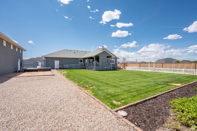 Fenced backyard with a patio | Image 98