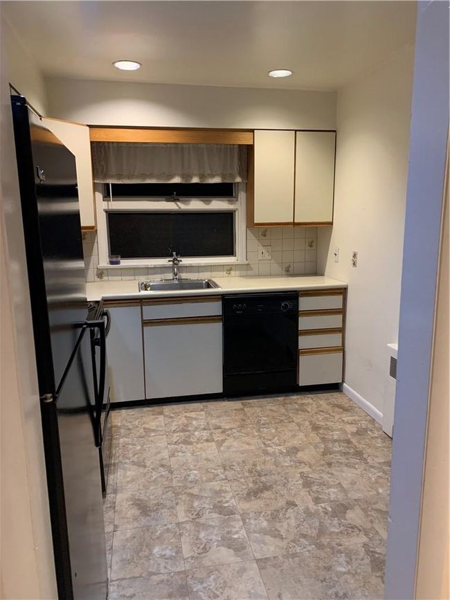 1st Fl Kitchen featuring white cabinets, sink, backsplash, fridge, and dishwasher | Image 16