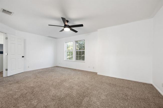 Carpeted empty room featuring visible vents, baseboards, and ceiling fan | Image 30