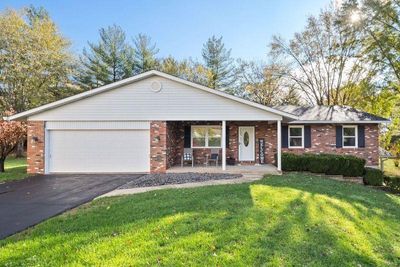 Ranch-style house with a front lawn and a garage | Image 1