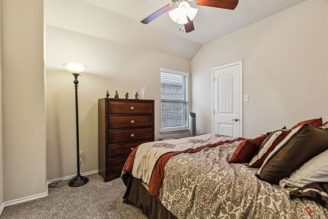 Carpeted bedroom featuring lofted ceiling, baseboards, and ceiling fan | Image 23