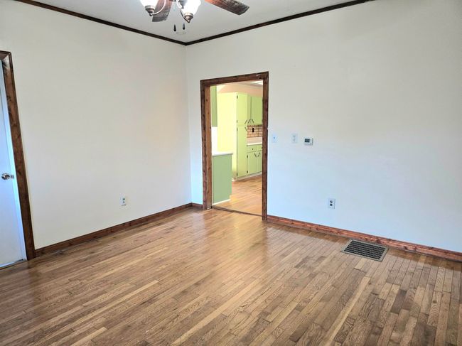 Spare room with ornamental molding, hardwood / wood-style floors, and ceiling fan | Image 6