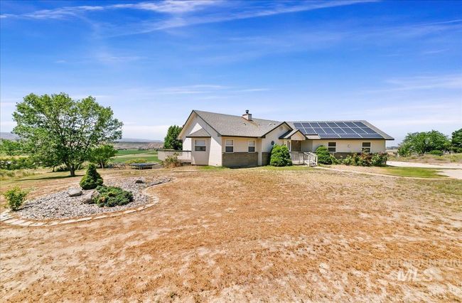 Ranch-style home featuring roof mounted solar panels and brick siding | Image 45