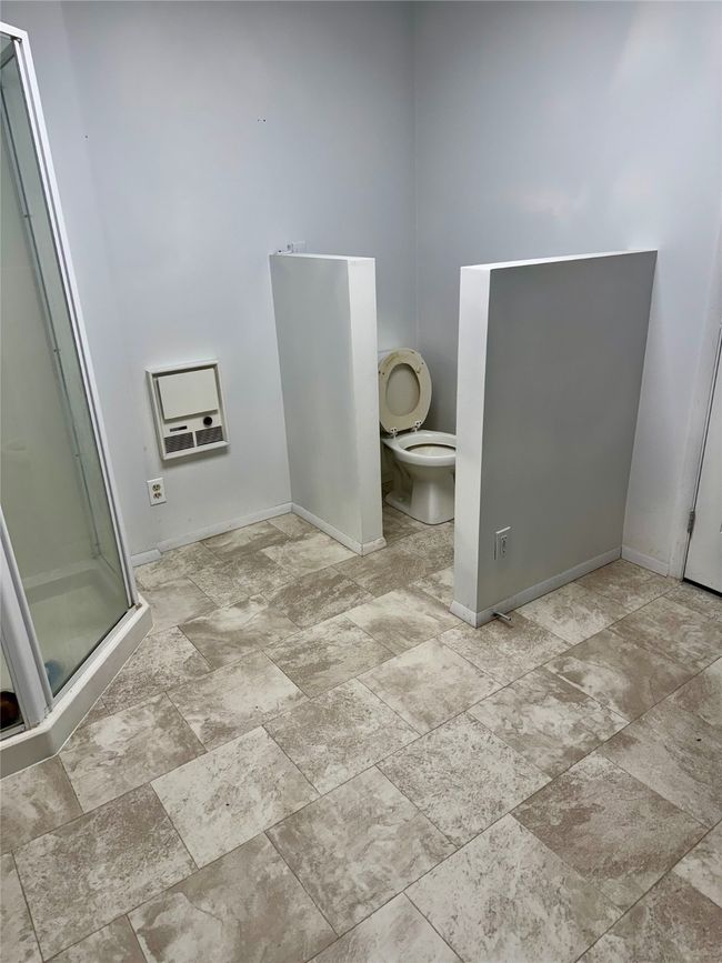 Full bathroom featuring toilet, a stall shower, and heat | Image 64