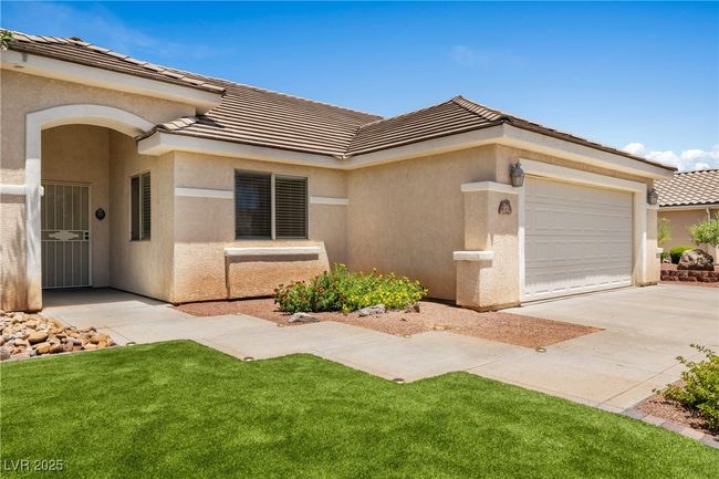 View of front of property featuring a garage, a tiled roof, concrete driveway, and stucco siding | Image 5