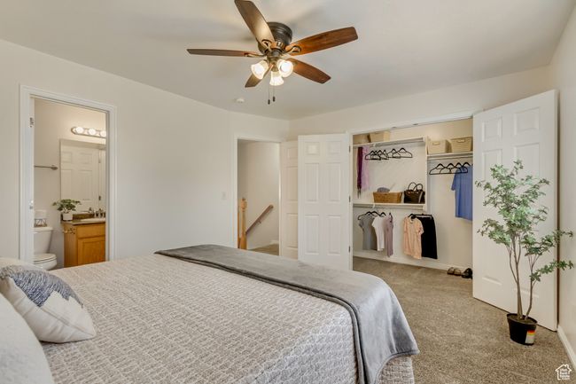 Carpeted bedroom with a closet, connected bathroom, and ceiling fan | Image 9
