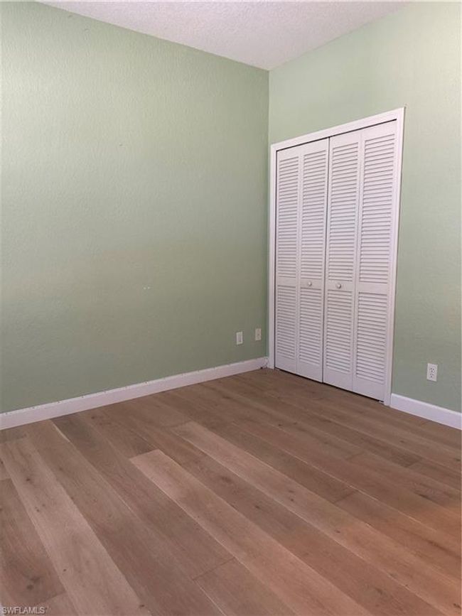 Unfurnished bedroom featuring a textured ceiling, hardwood / wood-style flooring, and a closet | Image 5