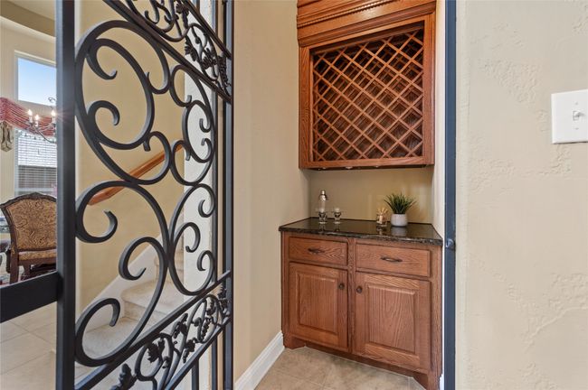 Wine room featuring a dry bar and light tile patterned floors | Image 12