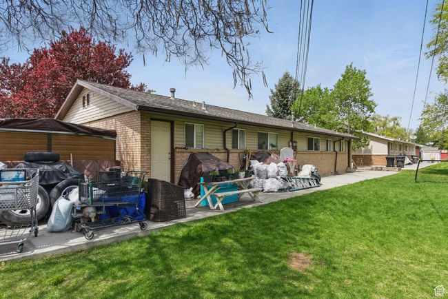 Rear view of house with a patio area, roof with shingles, brick siding, and a yard | Image 31