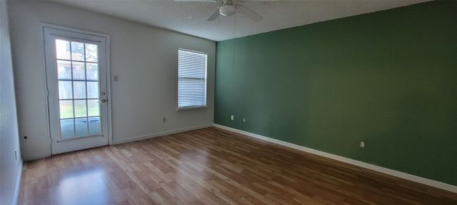Empty room featuring ceiling fan, wood finished floors, baseboards, and a textured ceiling | Image 12