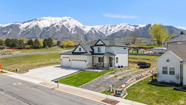 View of front of property featuring an attached garage, driveway, a mountain view, and a front yard | Image 5