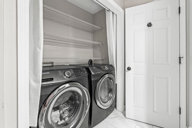 Washroom with washing machine and dryer and marble look tile flooring | Image 13