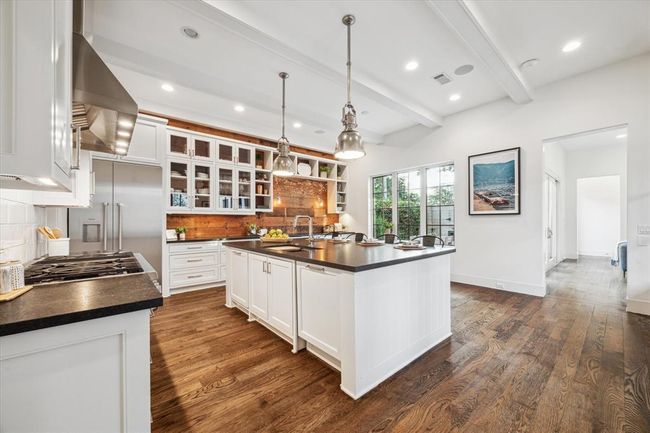 KITCHEN. The kitchen could have been lifted right off the pages of LUXE Magazine featuring Thermador appliances, soapstone countertops, oak accent paneling, a walk in pantry, designer pendants and under cabinet lighting. | Image 7