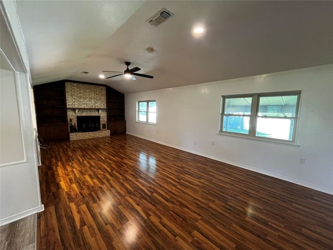 The grand living room with vaulted ceilings and beautiful built-in shelves | Image 11