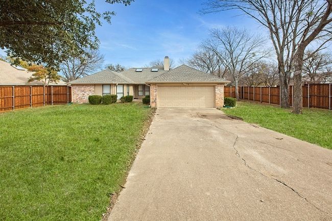Ranch-style home featuring a garage, driveway, a chimney, and brick siding | Image 5