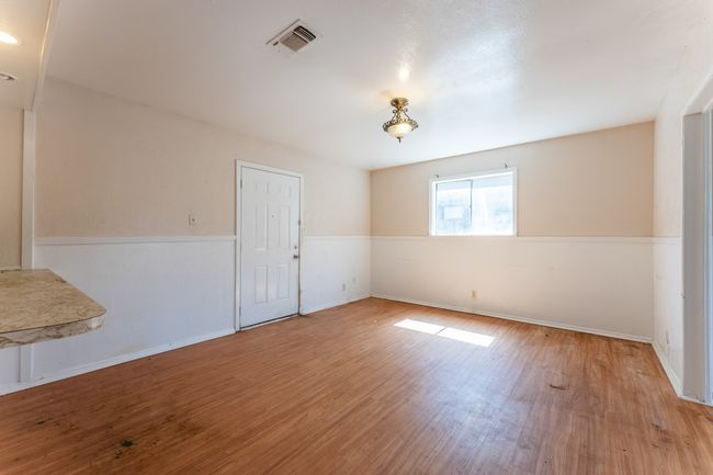 Unfurnished room with visible vents, baseboards, and wood finished floors | Image 13