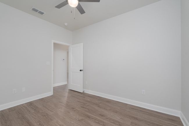Spare room featuring visible vents, baseboards, a ceiling fan, and wood finished floors | Image 29