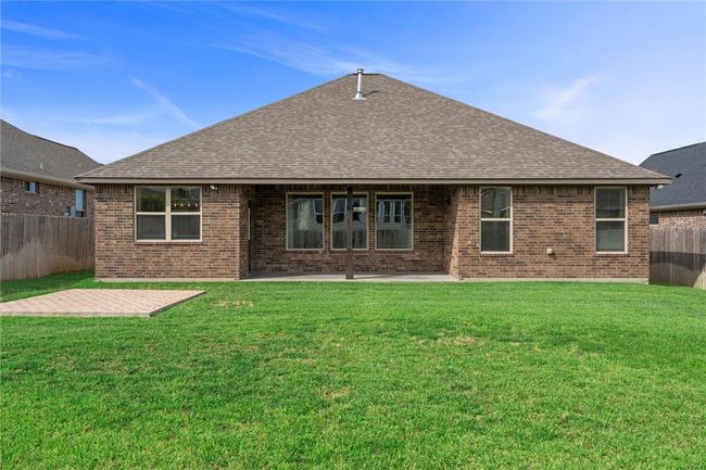 Rear view of property featuring a patio, roof with shingles, and brick siding | Image 32